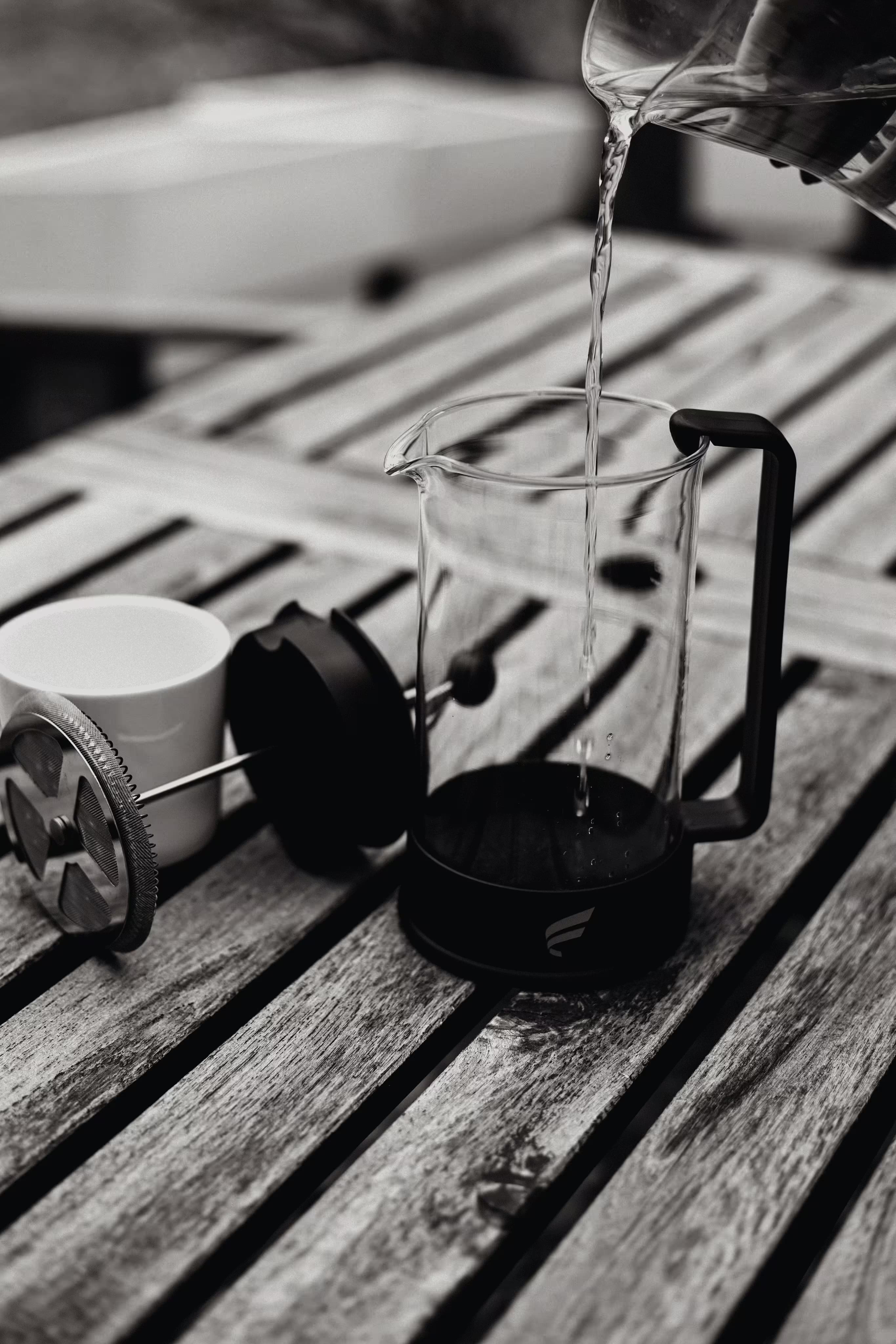 French press coffee maker with Fluent branding on wooden surface