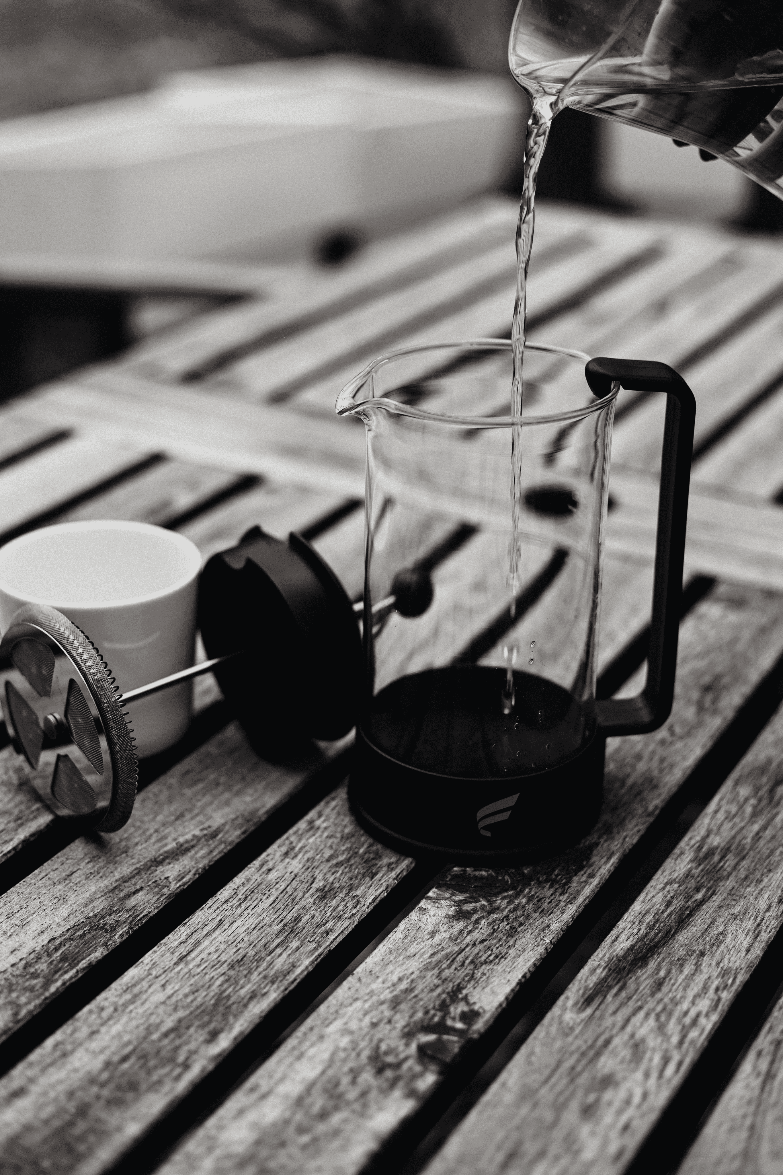French press coffee maker with Fluent branding on wooden surface